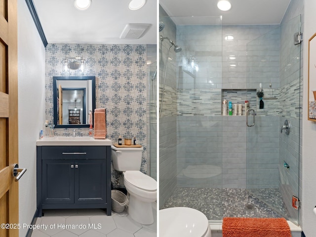 bathroom featuring tile patterned floors, vanity, toilet, and a shower with shower door