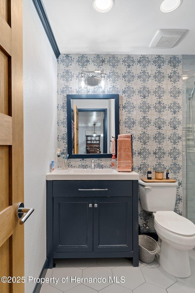 bathroom featuring tile patterned flooring, an enclosed shower, vanity, and toilet