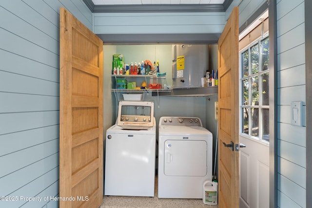 laundry area with wooden walls, washer and clothes dryer, and electric water heater