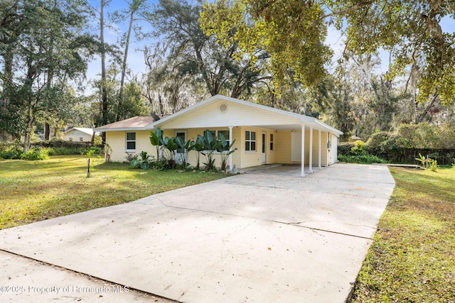 single story home with a front yard, a carport, and covered porch