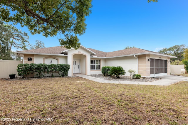 single story home featuring a garage and a front yard