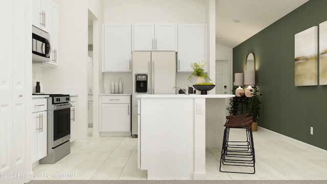 kitchen featuring vaulted ceiling, appliances with stainless steel finishes, light tile patterned floors, and white cabinets