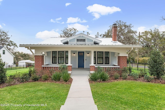 view of front of home with covered porch and a front lawn