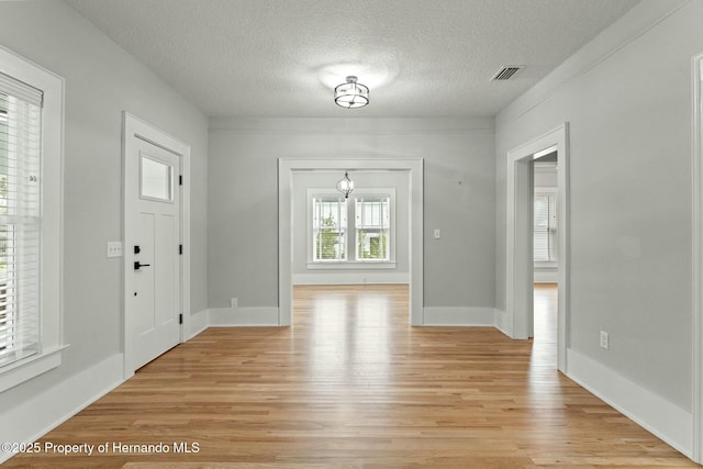 foyer entrance featuring light hardwood / wood-style flooring and a textured ceiling