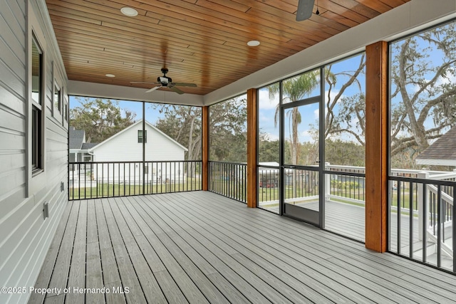 unfurnished sunroom featuring ceiling fan and wooden ceiling