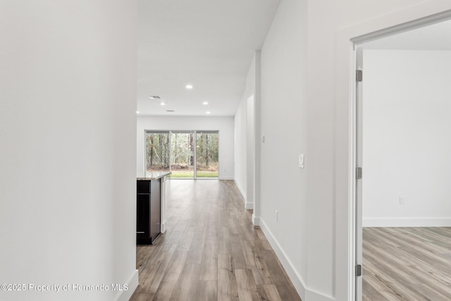 corridor with light hardwood / wood-style floors