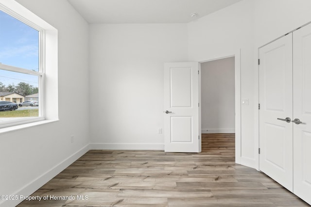 unfurnished bedroom with a closet and light wood-type flooring