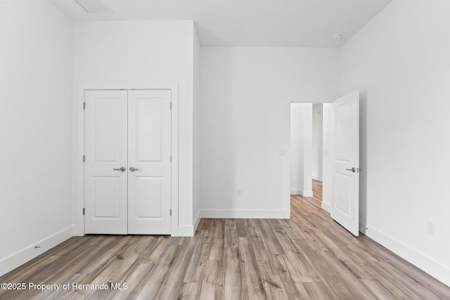 unfurnished bedroom featuring light hardwood / wood-style floors and a closet