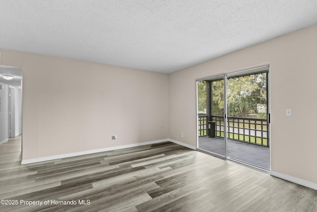 spare room featuring hardwood / wood-style flooring and a textured ceiling