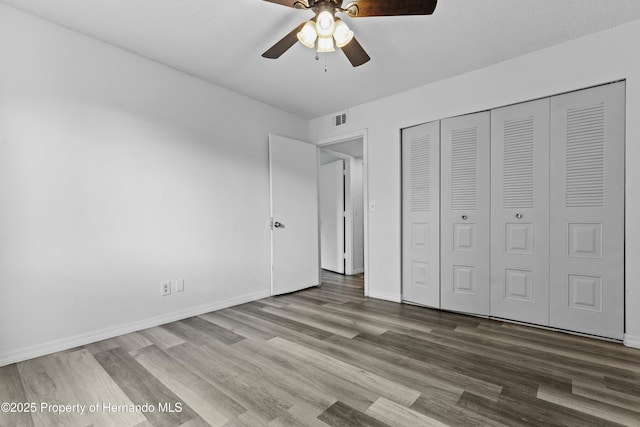 unfurnished bedroom with hardwood / wood-style flooring, a closet, and ceiling fan