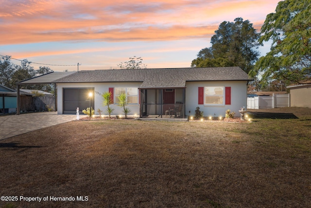 single story home featuring a garage and a yard