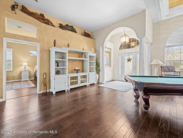 recreation room with beamed ceiling, dark hardwood / wood-style floors, and ornate columns