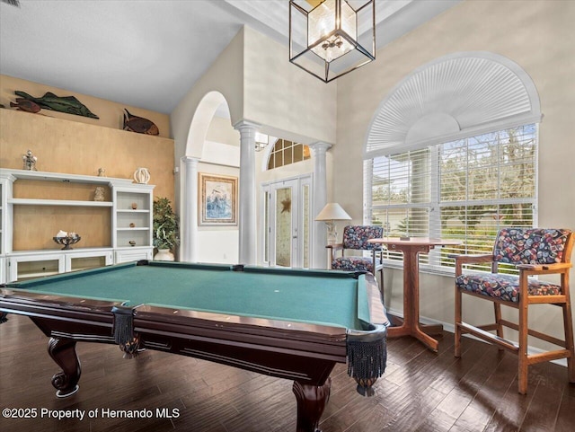 recreation room featuring dark hardwood / wood-style floors and ornate columns