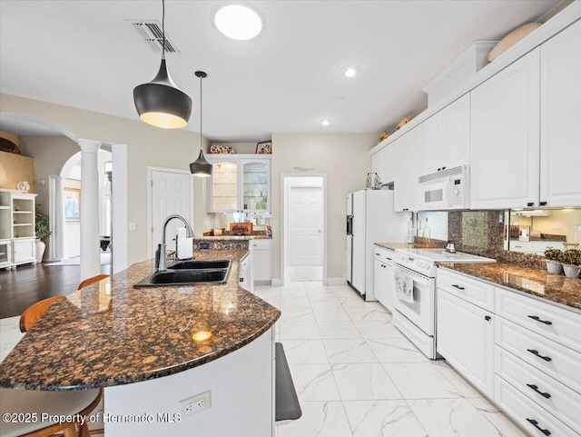 kitchen featuring white cabinetry, sink, white appliances, and a center island with sink