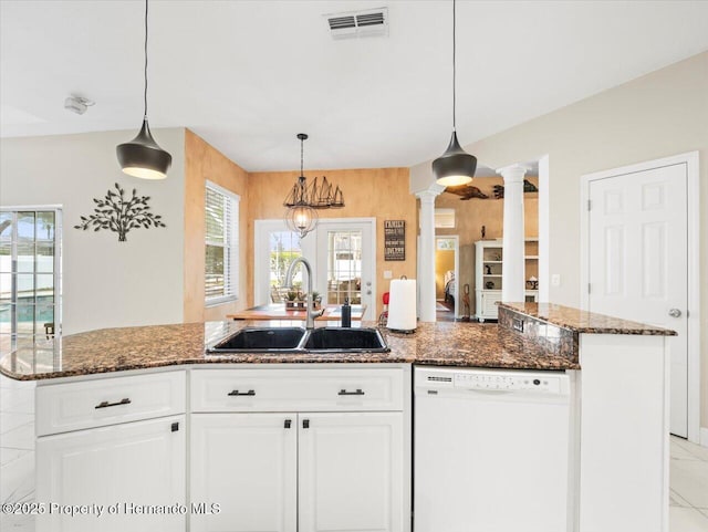 kitchen with sink, ornate columns, a center island with sink, white dishwasher, and white cabinets