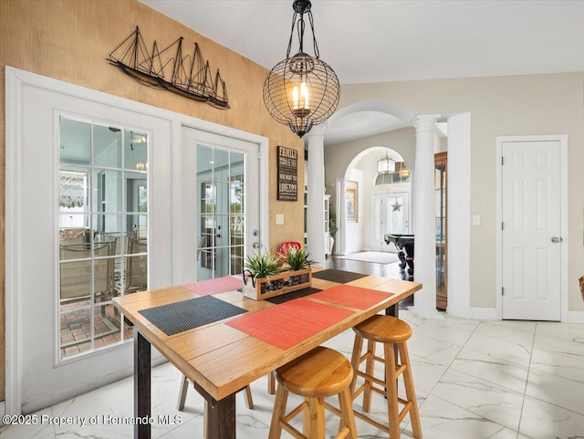 dining space with french doors and decorative columns