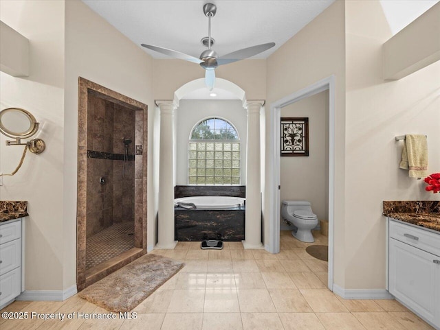 full bathroom featuring ornate columns, vanity, separate shower and tub, and toilet