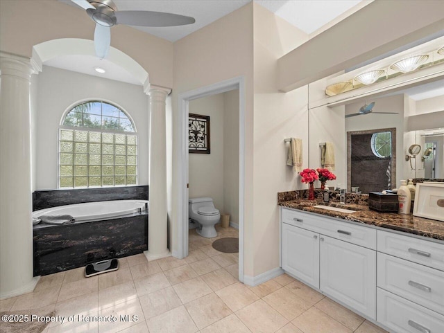 bathroom with toilet, decorative columns, vanity, ceiling fan, and tile patterned flooring