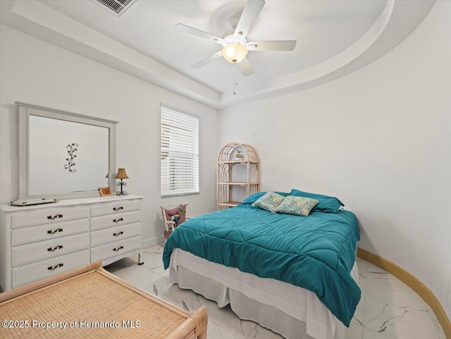 bedroom with a raised ceiling and ceiling fan