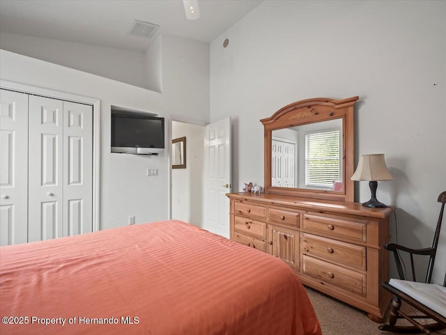 carpeted bedroom featuring ceiling fan and a closet