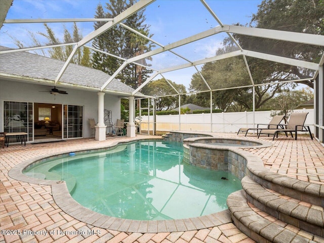 view of swimming pool featuring an in ground hot tub, ceiling fan, a patio, and glass enclosure