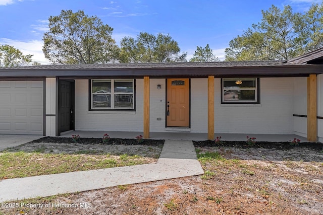 ranch-style home with covered porch and a garage