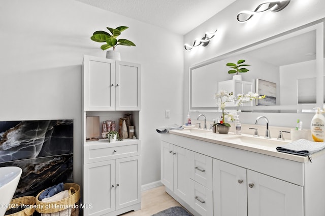 bathroom with vanity, hardwood / wood-style floors, and a textured ceiling