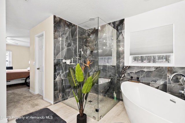 bathroom with separate shower and tub, sink, tile walls, and a textured ceiling