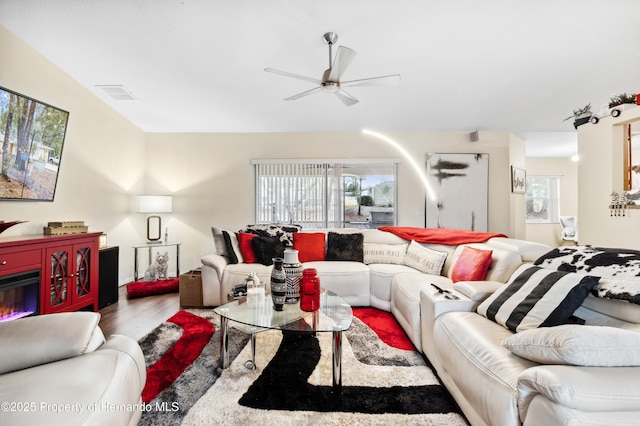 living room featuring wood-type flooring and ceiling fan