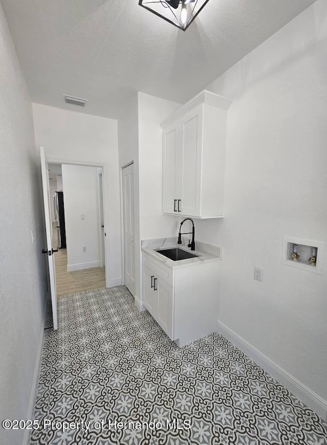 laundry area featuring washer hookup, sink, and a textured ceiling