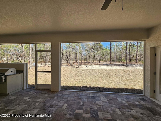 unfurnished sunroom featuring ceiling fan