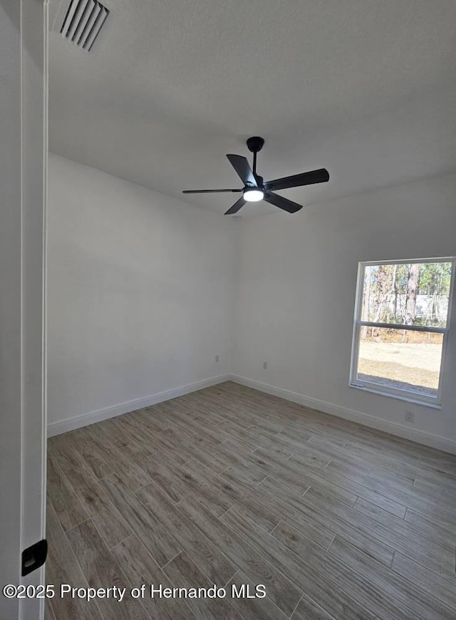 empty room with ceiling fan and light wood-type flooring