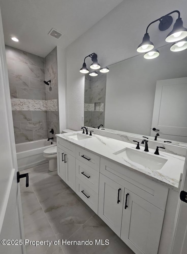 full bathroom with tiled shower / bath combo, vanity, and toilet