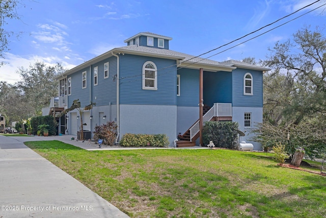 view of front property featuring central AC unit, a garage, and a front lawn