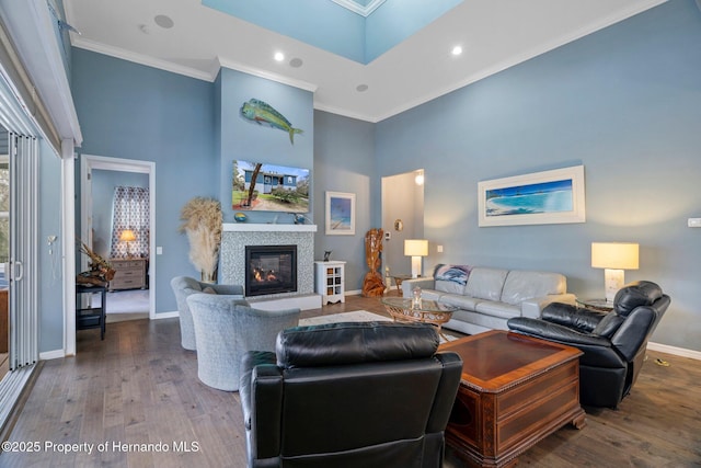 living room featuring ornamental molding, wood-type flooring, and a towering ceiling