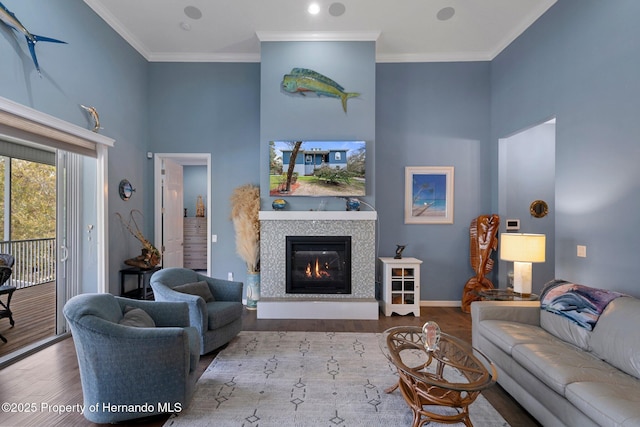 living room featuring a fireplace, ornamental molding, and light hardwood / wood-style floors