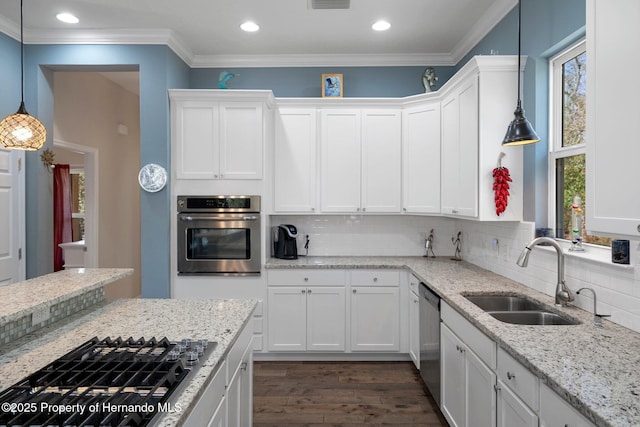 kitchen with stainless steel appliances, white cabinetry, hanging light fixtures, and sink