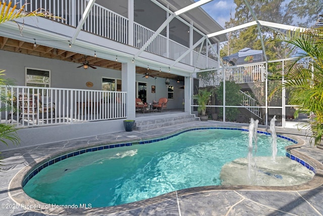 view of swimming pool featuring pool water feature, ceiling fan, a lanai, and a patio