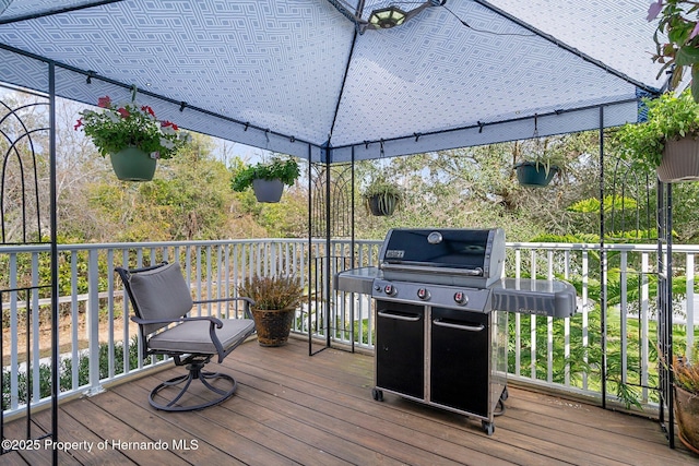 wooden deck featuring a gazebo and a grill