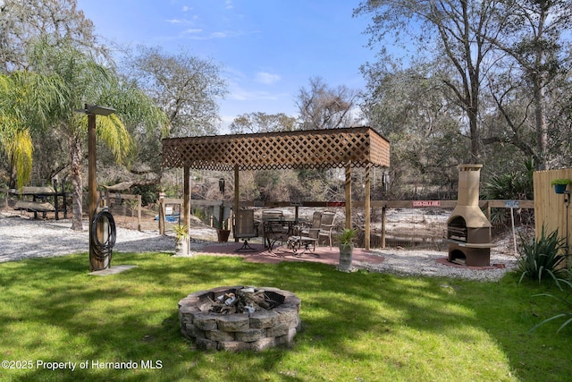 view of community featuring a lawn and an outdoor fire pit