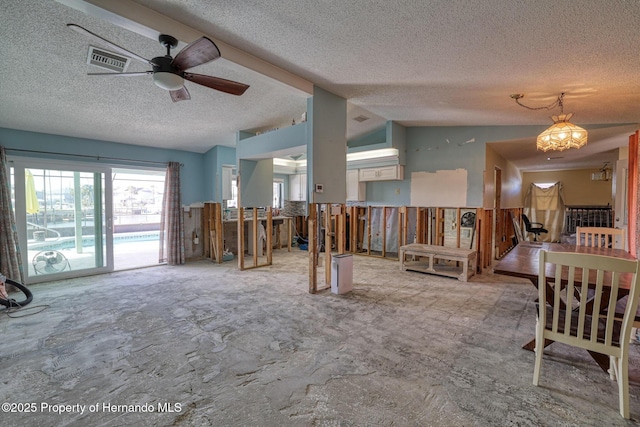 interior space with vaulted ceiling, ceiling fan, and a textured ceiling