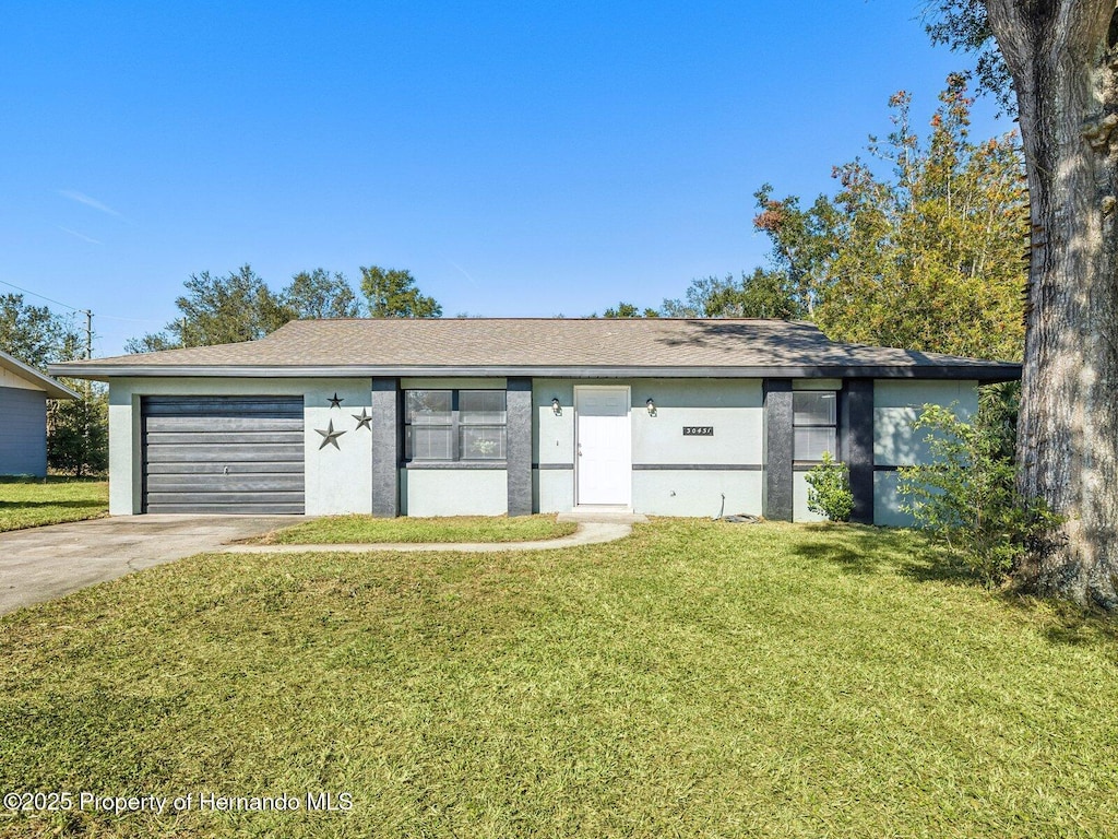 ranch-style home featuring a garage and a front yard