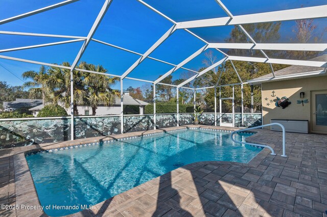 view of swimming pool featuring a lanai and a patio area