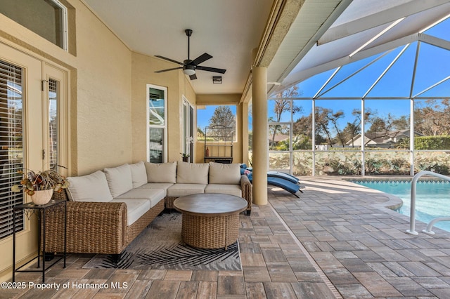 view of patio / terrace featuring an outdoor hangout area, ceiling fan, and glass enclosure