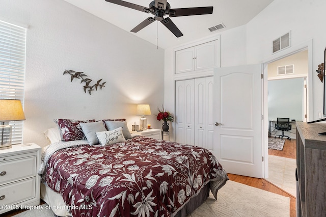 bedroom with light hardwood / wood-style flooring, a closet, ceiling fan, and vaulted ceiling