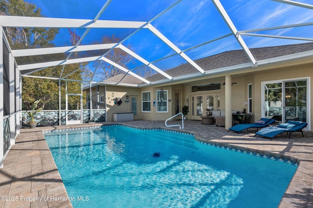 view of swimming pool featuring ceiling fan, a patio area, glass enclosure, and french doors