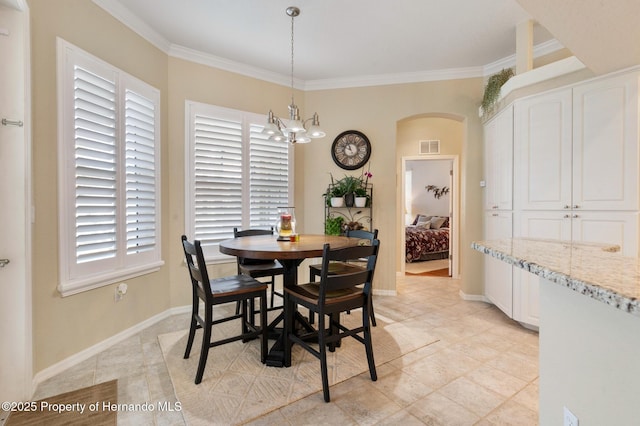 dining room featuring a wealth of natural light, ornamental molding, and a chandelier