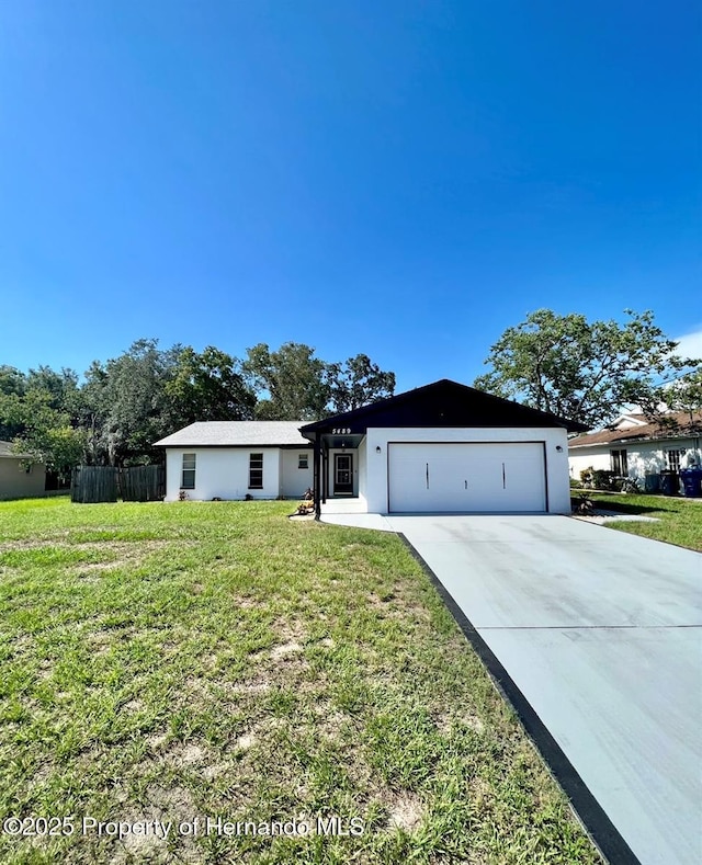 single story home with a garage and a front lawn