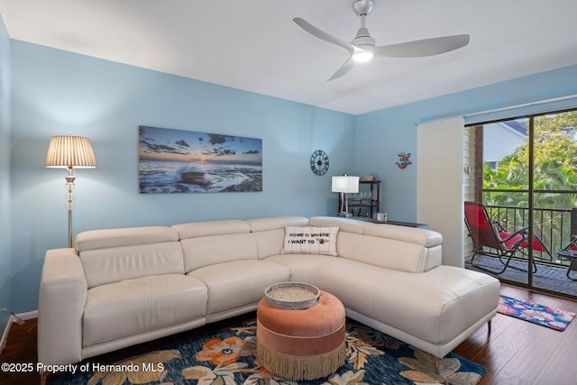 living room featuring dark wood-type flooring and ceiling fan