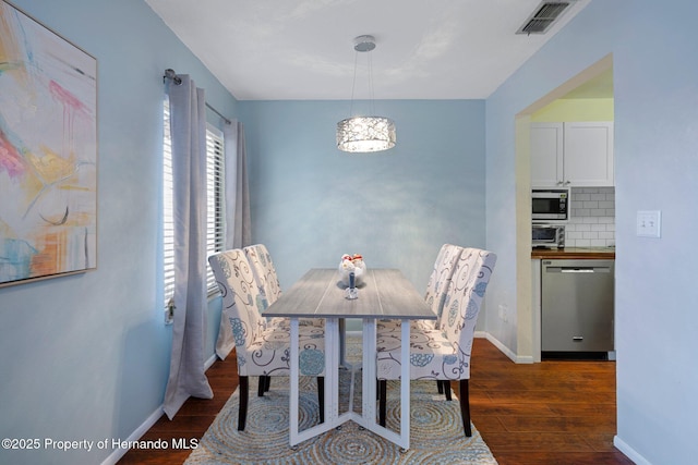 dining room with dark hardwood / wood-style flooring